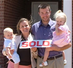 Family holding sold sign